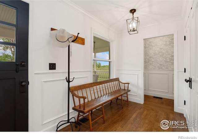 7215 Hygiene Rd, Longmont, CO 80503 - entrance foyer featuring wood finished floors, a decorative wall, a chandelier, ornamental molding, and wainscoting