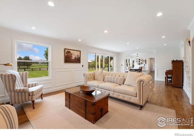 7215 Hygiene Rd, Longmont, CO 80503 - living room with a decorative wall, arched walkways, ornamental molding, light wood-type flooring, and recessed lighting