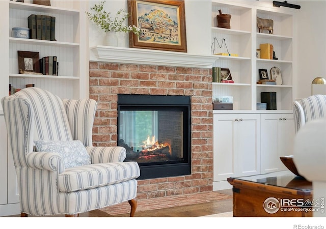 7215 Hygiene Rd, Longmont, CO 80503 - sitting room with a brick fireplace, wood finished floors, and built in features