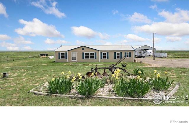 39780 County Road 68, Briggsdale, CO 80611 - single story home featuring dirt driveway, a front lawn, metal roof, and stucco siding