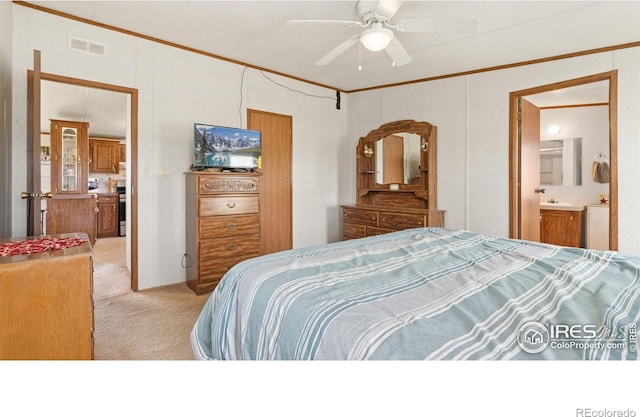 39780 County Road 68, Briggsdale, CO 80611 - bedroom with light carpet, ornamental molding, connected bathroom, and a ceiling fan
