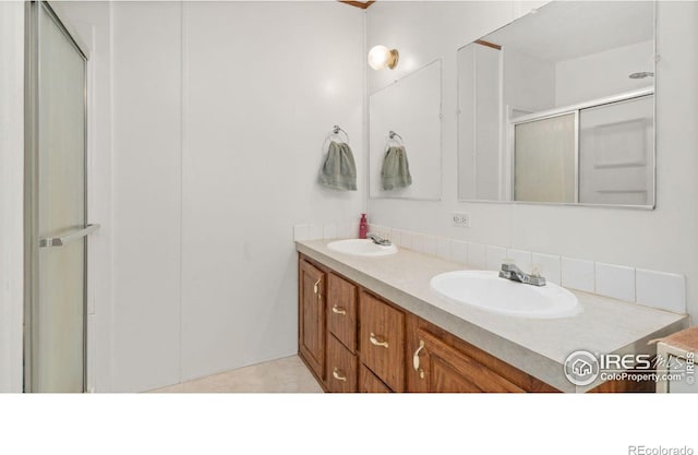 39780 County Road 68, Briggsdale, CO 80611 - bathroom featuring double vanity, a stall shower, and tasteful backsplash