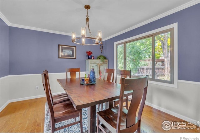 11290 Ranch Pl, Denver, CO 80234 - dining room with wood finished floors, a chandelier, crown molding, and baseboards