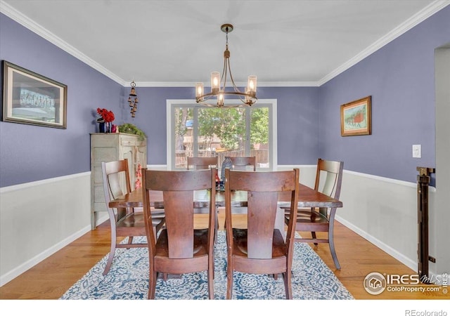 11290 Ranch Pl, Denver, CO 80234 - dining area featuring wood finished floors, a chandelier, ornamental molding, and baseboards