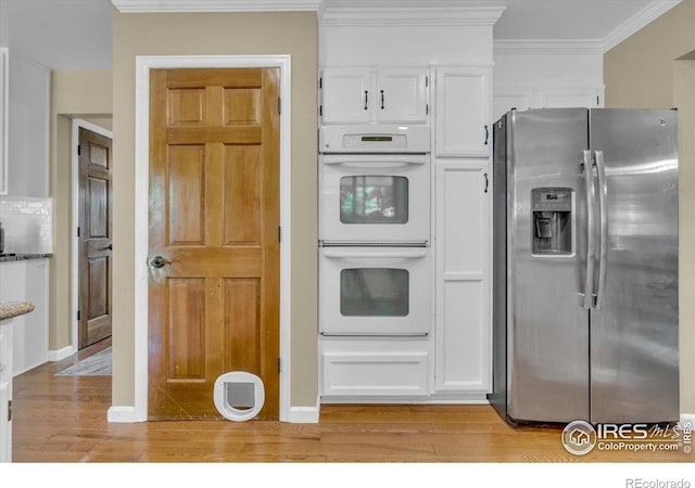 11290 Ranch Pl, Denver, CO 80234 - kitchen with stainless steel refrigerator with ice dispenser, white double oven, white cabinets, light wood finished floors, and ornamental molding