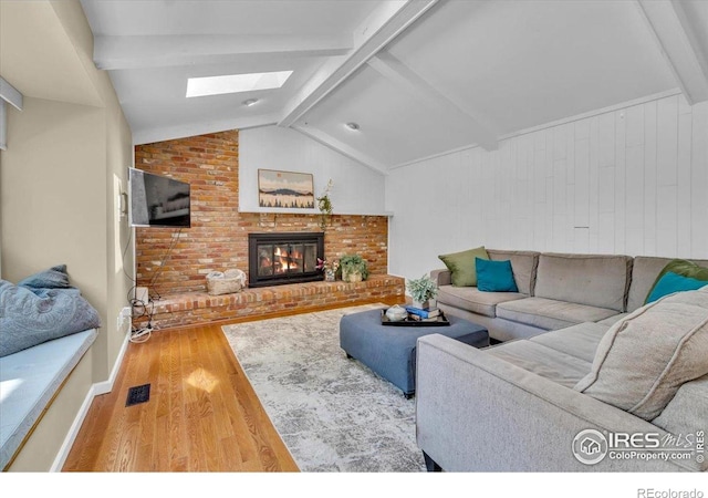 11290 Ranch Pl, Denver, CO 80234 - living room with a skylight, wood finished floors, a brick fireplace, and baseboards