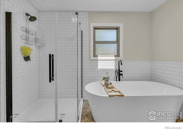 11290 Ranch Pl, Denver, CO 80234 - bathroom with a stall shower, tile walls, and a freestanding tub
