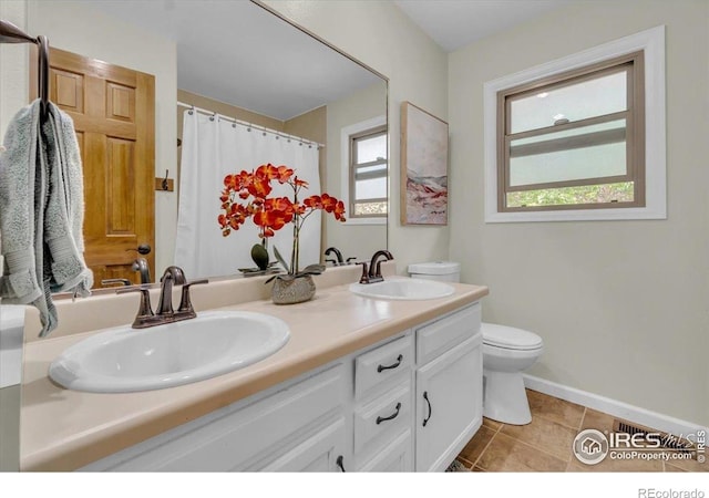 11290 Ranch Pl, Denver, CO 80234 - bathroom featuring toilet, double vanity, tile patterned floors, baseboards, and a shower with shower curtain