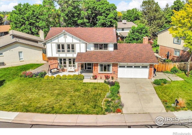 11290 Ranch Pl, Denver, CO 80234 - tudor-style house featuring a garage, concrete driveway, brick siding, and a chimney