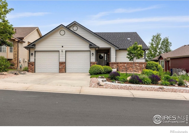 2325 Birdie Way, Milliken, CO 80543 - view of front facade with brick siding, an attached garage, concrete driveway, and a shingled roof