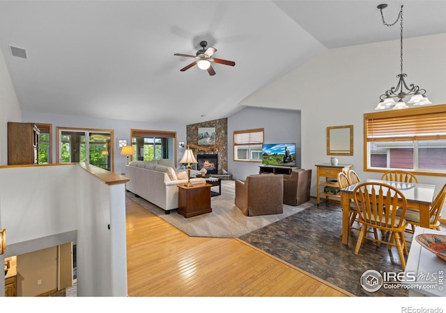 2325 Birdie Way, Milliken, CO 80543 - living area featuring lofted ceiling, wood finished floors, a ceiling fan, and a fireplace