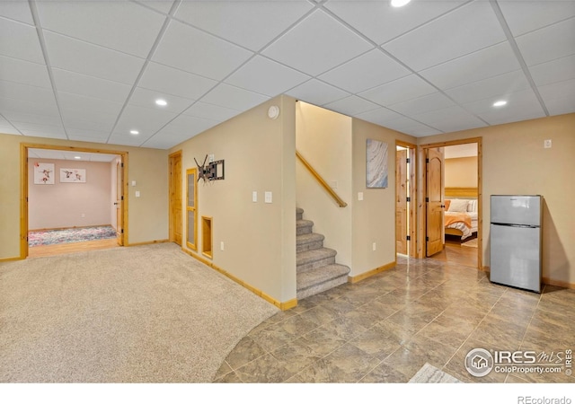 2325 Birdie Way, Milliken, CO 80543 - finished basement with freestanding refrigerator, a drop ceiling, baseboards, stairs, and recessed lighting
