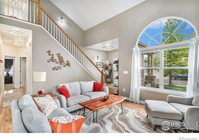 264 Alder Ave, Johnstown, CO 80534 - living room with a towering ceiling, wood finished floors, stairway, and baseboards