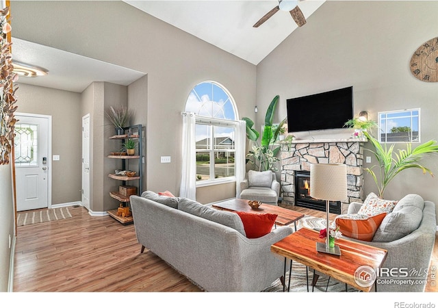 264 Alder Ave, Johnstown, CO 80534 - living room with wood finished floors, a ceiling fan, a fireplace, high vaulted ceiling, and baseboards