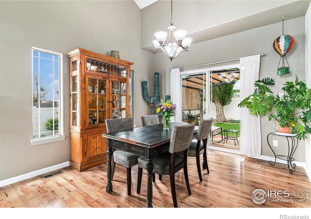 264 Alder Ave, Johnstown, CO 80534 - dining area featuring a chandelier, baseboards, high vaulted ceiling, and light wood-style floors