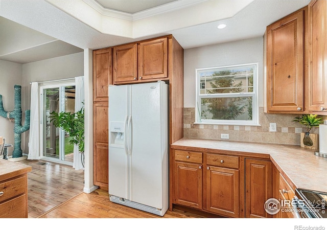 264 Alder Ave, Johnstown, CO 80534 - kitchen featuring white fridge with ice dispenser, brown cabinets, light countertops, light wood-type flooring, and recessed lighting