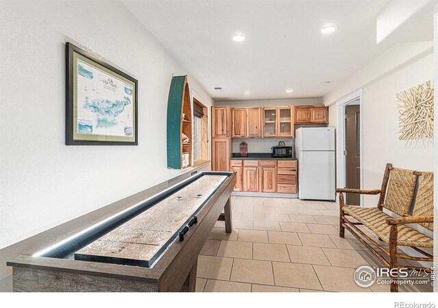 264 Alder Ave, Johnstown, CO 80534 - kitchen with freestanding refrigerator, recessed lighting, glass insert cabinets, dark countertops, and light tile patterned floors