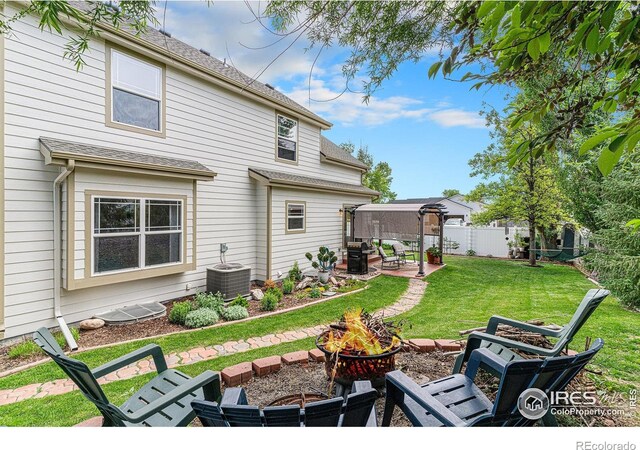 264 Alder Ave, Johnstown, CO 80534 - back of property featuring an outdoor fire pit, cooling unit, a patio, and roof with shingles