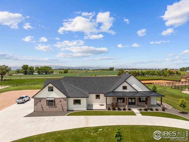 37179 Soaring Eagle Cir, Severance, CO 80550 - modern farmhouse with a porch, curved driveway, brick siding, and a view of countryside
