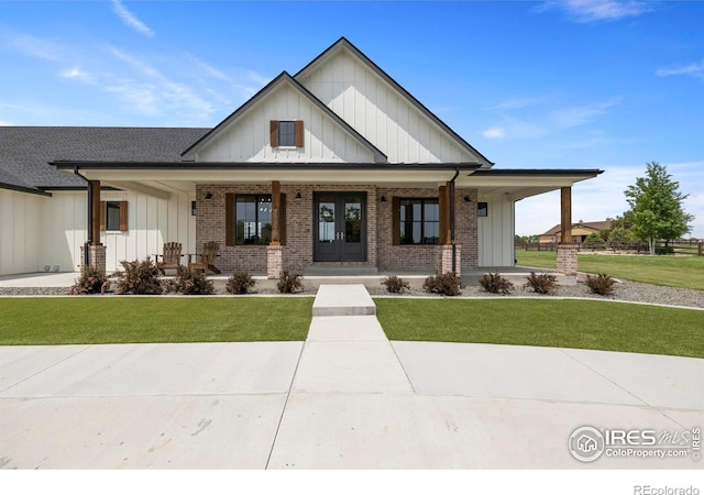 37179 Soaring Eagle Cir, Severance, CO 80550 - modern farmhouse style home featuring board and batten siding, covered porch, a front lawn, and brick siding