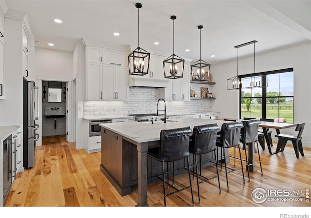 37179 Soaring Eagle Cir, Severance, CO 80550 - kitchen with stainless steel appliances, a sink, tasteful backsplash, a center island with sink, and recessed lighting