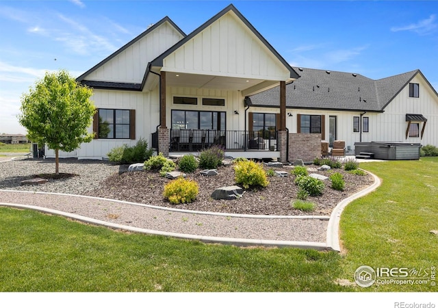 37179 Soaring Eagle Cir, Severance, CO 80550 - back of house featuring a hot tub, board and batten siding, a yard, and a shingled roof