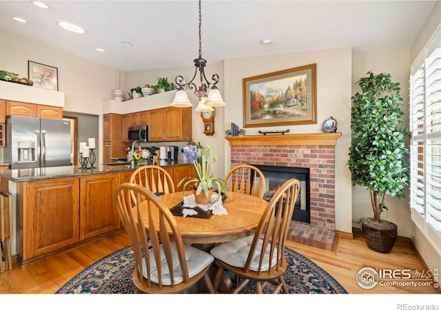 1142 Muirfield Way, Fort Collins, CO 80525 - dining area featuring light wood-type flooring, a fireplace, recessed lighting, and baseboards