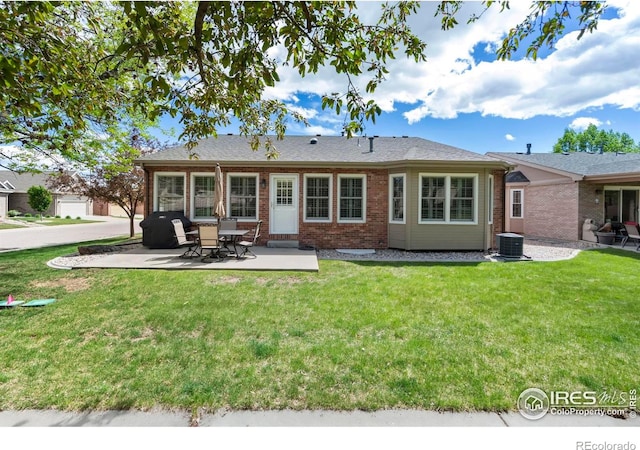 1142 Muirfield Way, Fort Collins, CO 80525 - back of house featuring brick siding, central AC, a patio, and a lawn