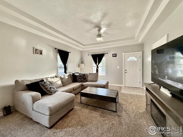 541 S Phelan Ave, Holyoke, CO 80734 - tiled living room with a raised ceiling, ceiling fan, a textured ceiling, and carpet flooring