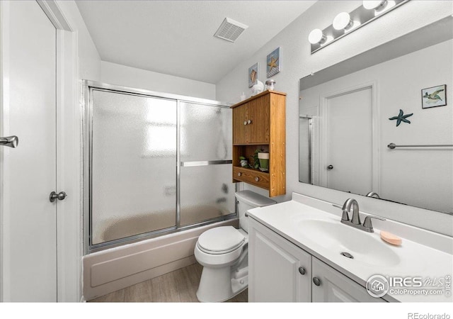 420 E 50th St, Loveland, CO 80538 - bathroom with vanity, combined bath / shower with glass door, toilet, and wood finished floors