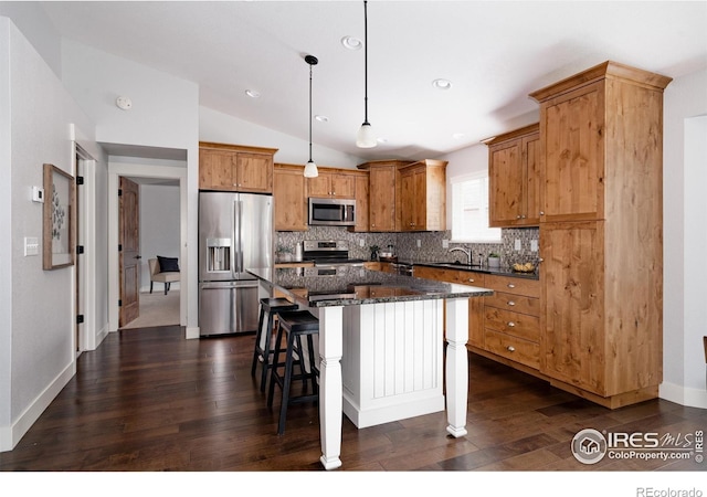 455 Radiant Dr, Loveland, CO 80538 - kitchen with stainless steel appliances, a sink, vaulted ceiling, backsplash, and a breakfast bar area