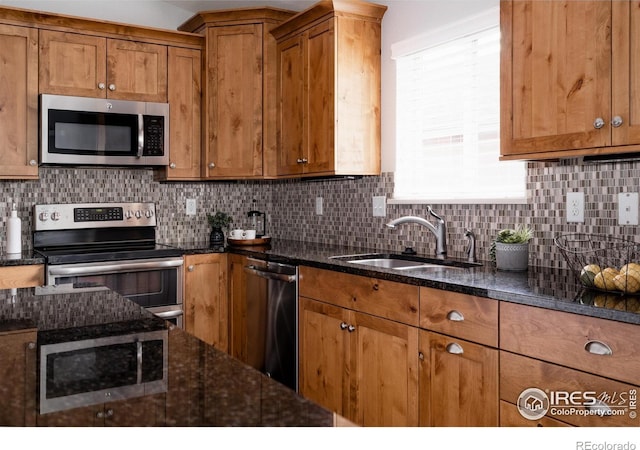 455 Radiant Dr, Loveland, CO 80538 - kitchen with stainless steel appliances, a sink, brown cabinets, and tasteful backsplash