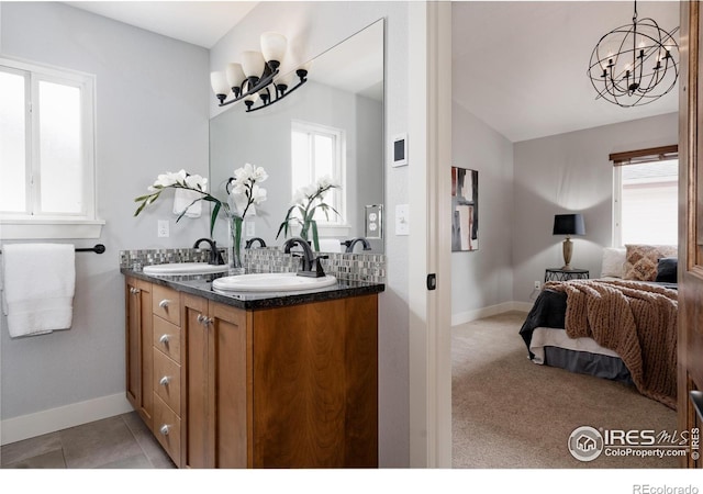 455 Radiant Dr, Loveland, CO 80538 - ensuite bathroom with a chandelier, double vanity, and baseboards