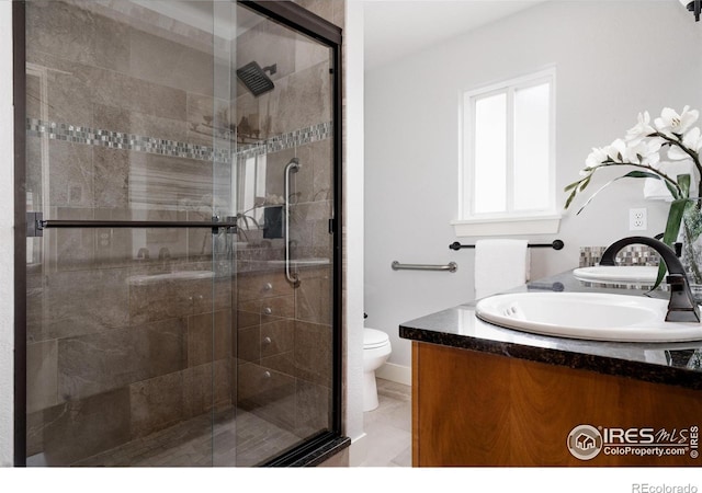 455 Radiant Dr, Loveland, CO 80538 - full bathroom with a stall shower, toilet, vanity, and marble finish floors