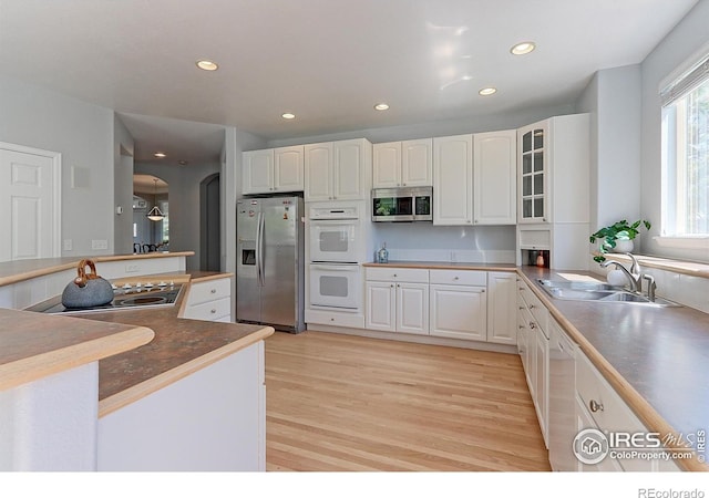 7858 Oban Ct, Lone Tree, CO 80124 - kitchen featuring appliances with stainless steel finishes, a sink, light wood-type flooring, white cabinetry, and recessed lighting