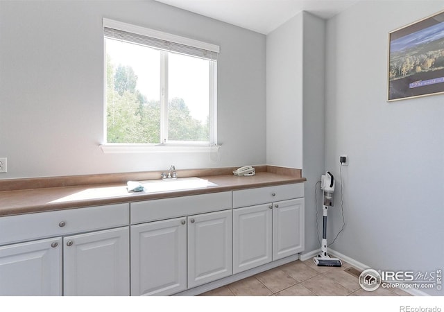 7858 Oban Ct, Lone Tree, CO 80124 - laundry area with light tile patterned floors, a sink, and baseboards