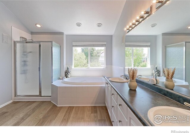 7858 Oban Ct, Lone Tree, CO 80124 - full bath with wood finished floors, a garden tub, double vanity, a stall shower, and recessed lighting