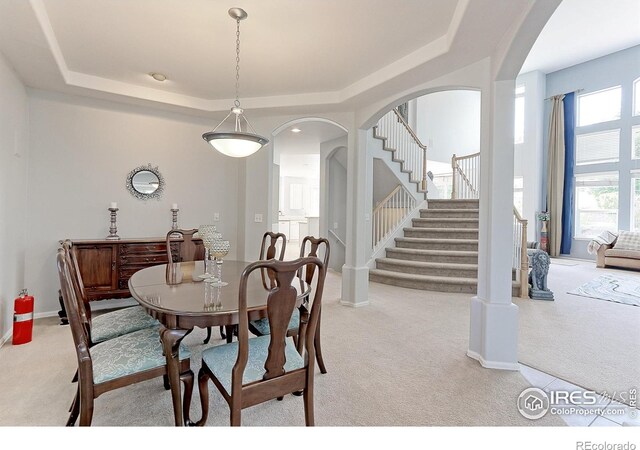 7858 Oban Ct, Lone Tree, CO 80124 - carpeted dining space featuring arched walkways, stairs, a raised ceiling, and baseboards