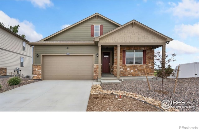 4709 Lynxes Way, Johnstown, CO 80534 - craftsman-style home featuring stone siding, concrete driveway, an attached garage, and covered porch