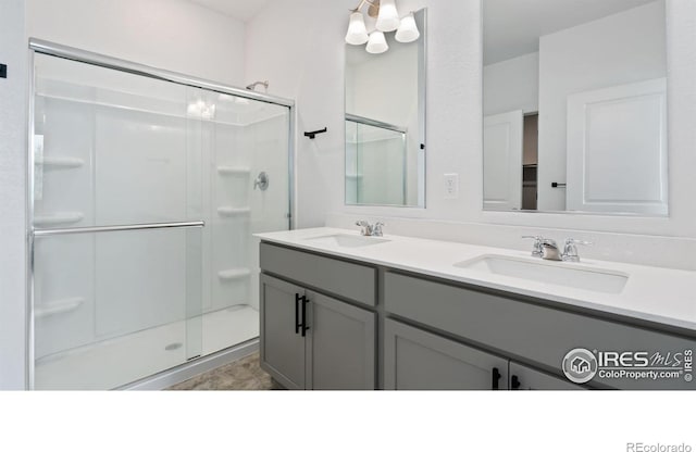 4709 Lynxes Way, Johnstown, CO 80534 - bathroom featuring a stall shower, double vanity, and a chandelier