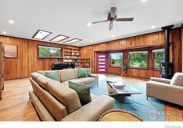 1484 Wicklow St, Boulder, CO 80303 - living room with wooden walls, a wood stove, recessed lighting, light wood-style floors, and ceiling fan