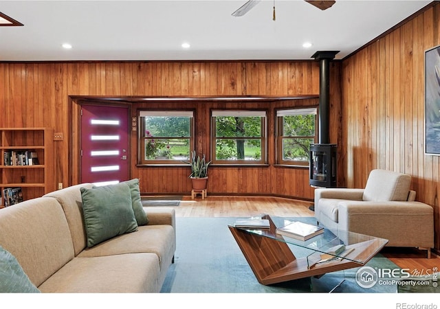 1484 Wicklow St, Boulder, CO 80303 - living area featuring wood walls, healthy amount of natural light, wood finished floors, a wood stove, and ceiling fan