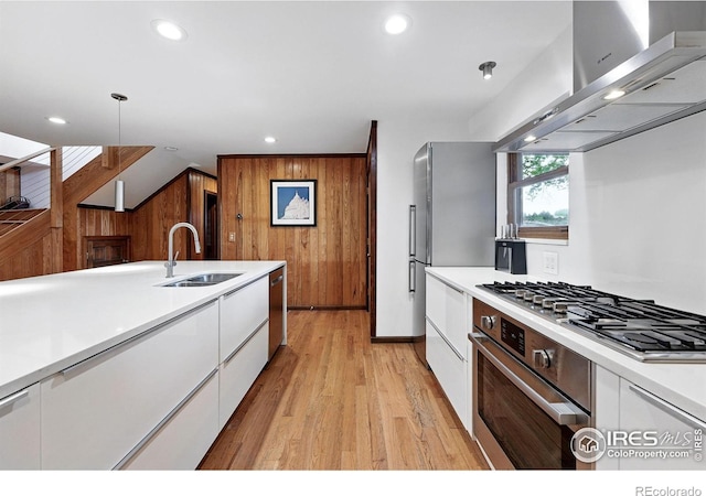 1484 Wicklow St, Boulder, CO 80303 - kitchen with a sink, wall chimney range hood, white cabinetry, wooden walls, and light wood finished floors