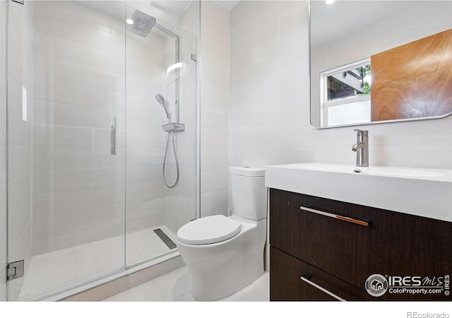 1484 Wicklow St, Boulder, CO 80303 - bathroom with a shower stall, vanity, toilet, tile patterned floors, and tile walls