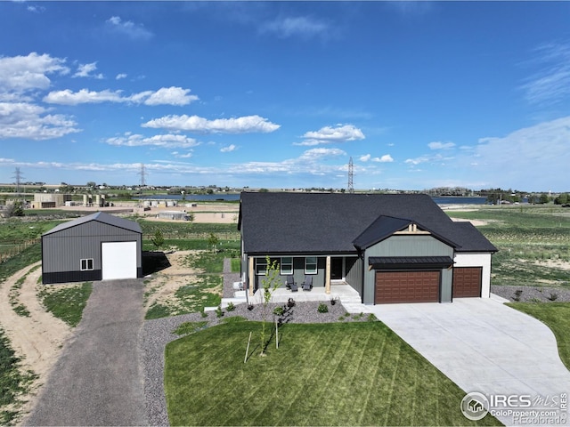 5016 Prairie Lark Ln, Severance, CO 80615 - view of front facade with covered porch, concrete driveway, a garage, a front lawn, and a shingled roof