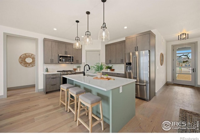 5016 Prairie Lark Ln, Severance, CO 80615 - kitchen featuring stainless steel appliances, a kitchen breakfast bar, light wood-style floors, light countertops, and recessed lighting