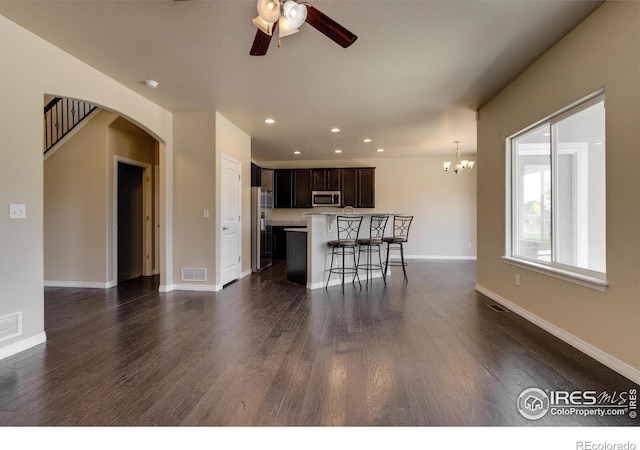 13598 Horseshoe Cir, Mead, CO 80542 - kitchen with appliances with stainless steel finishes, arched walkways, ceiling fan, a breakfast bar area, and light countertops