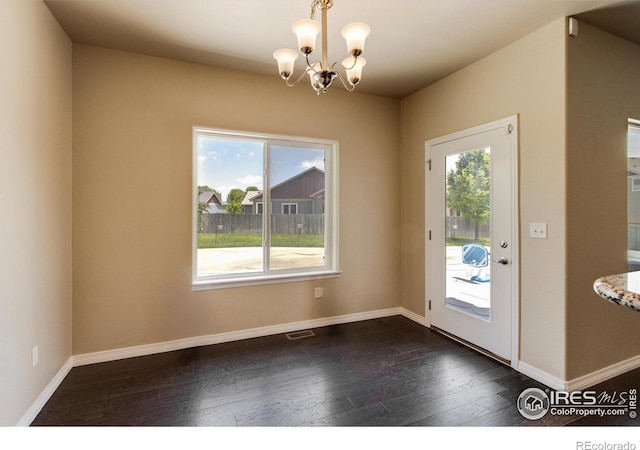 13598 Horseshoe Cir, Mead, CO 80542 - doorway to outside with a chandelier, plenty of natural light, dark wood finished floors, and baseboards