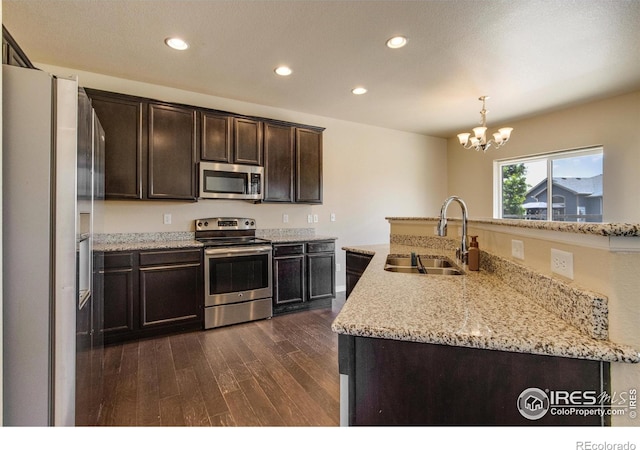 13598 Horseshoe Cir, Mead, CO 80542 - kitchen with stainless steel appliances, a sink, dark wood-type flooring, dark brown cabinets, and recessed lighting
