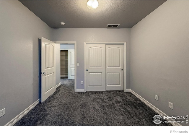 13598 Horseshoe Cir, Mead, CO 80542 - unfurnished bedroom with dark carpet, a textured ceiling, baseboards, and a closet